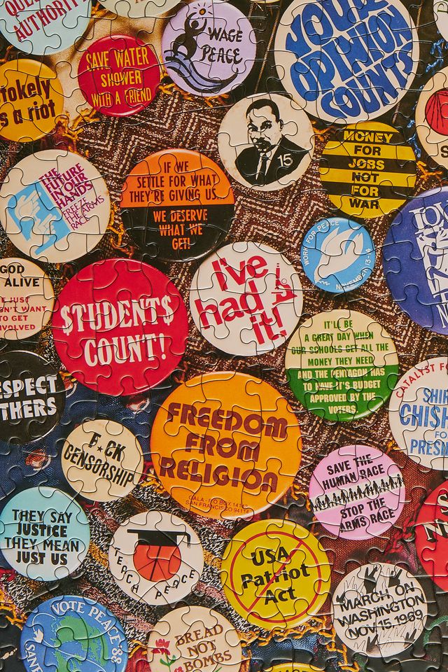 Collection of vintage buttons with various messages on a puzzle background