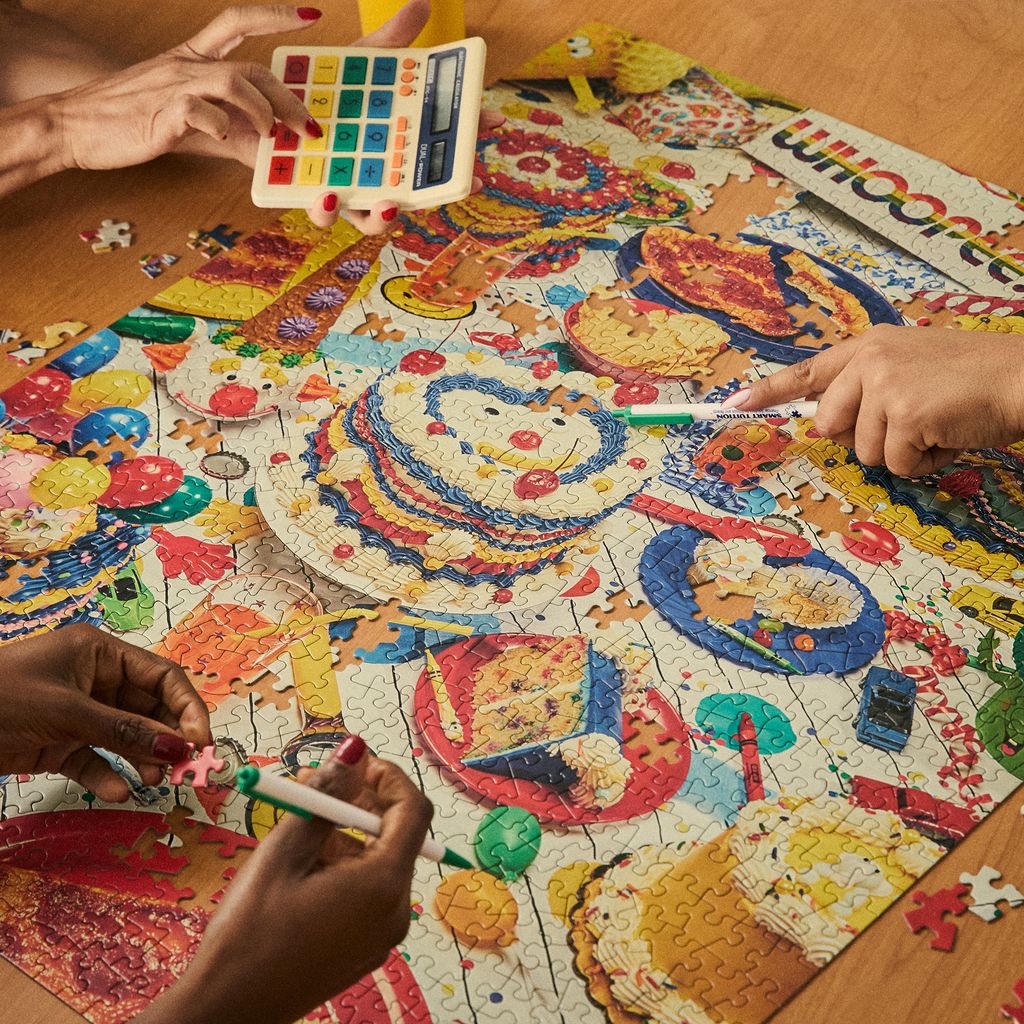 Color swatch app over a colorful puzzle with hands working on it
