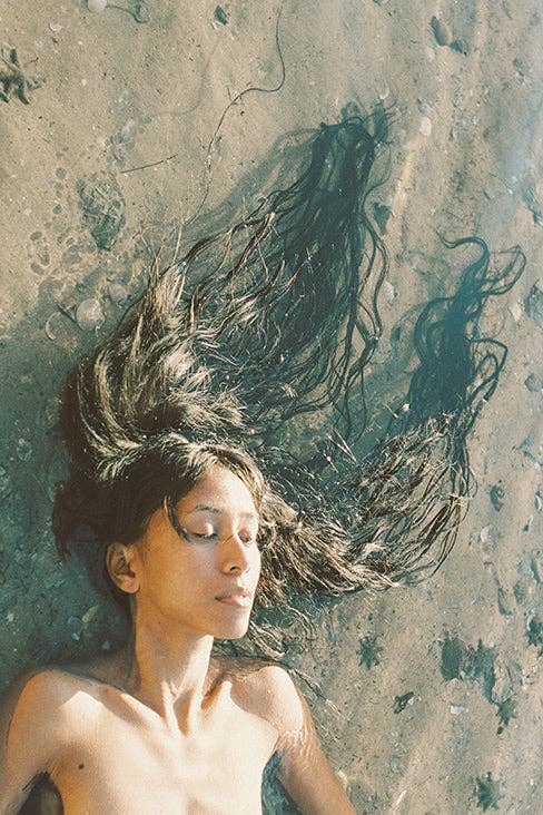 Woman with flowing hair against a textured wall