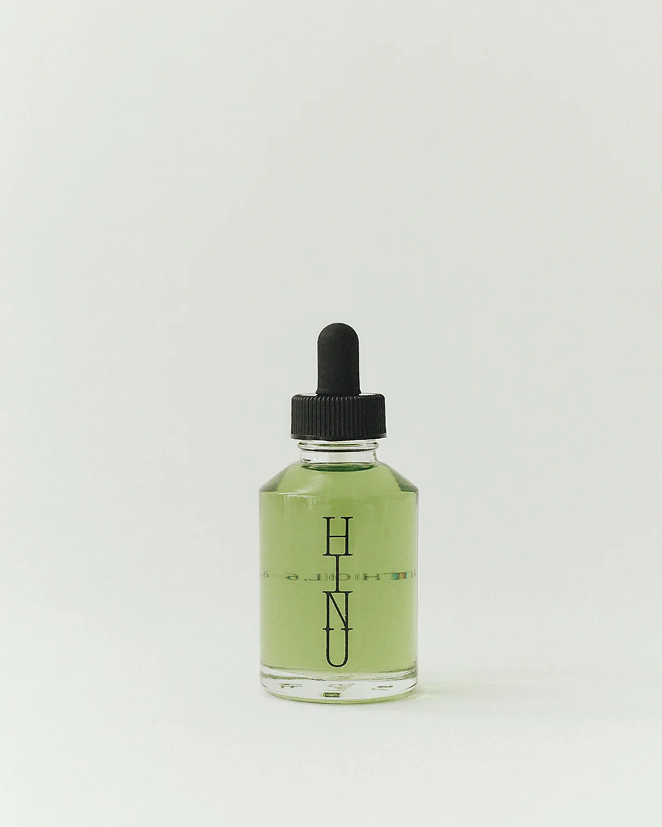 Bottle of green liquid with a black dropper on a white background