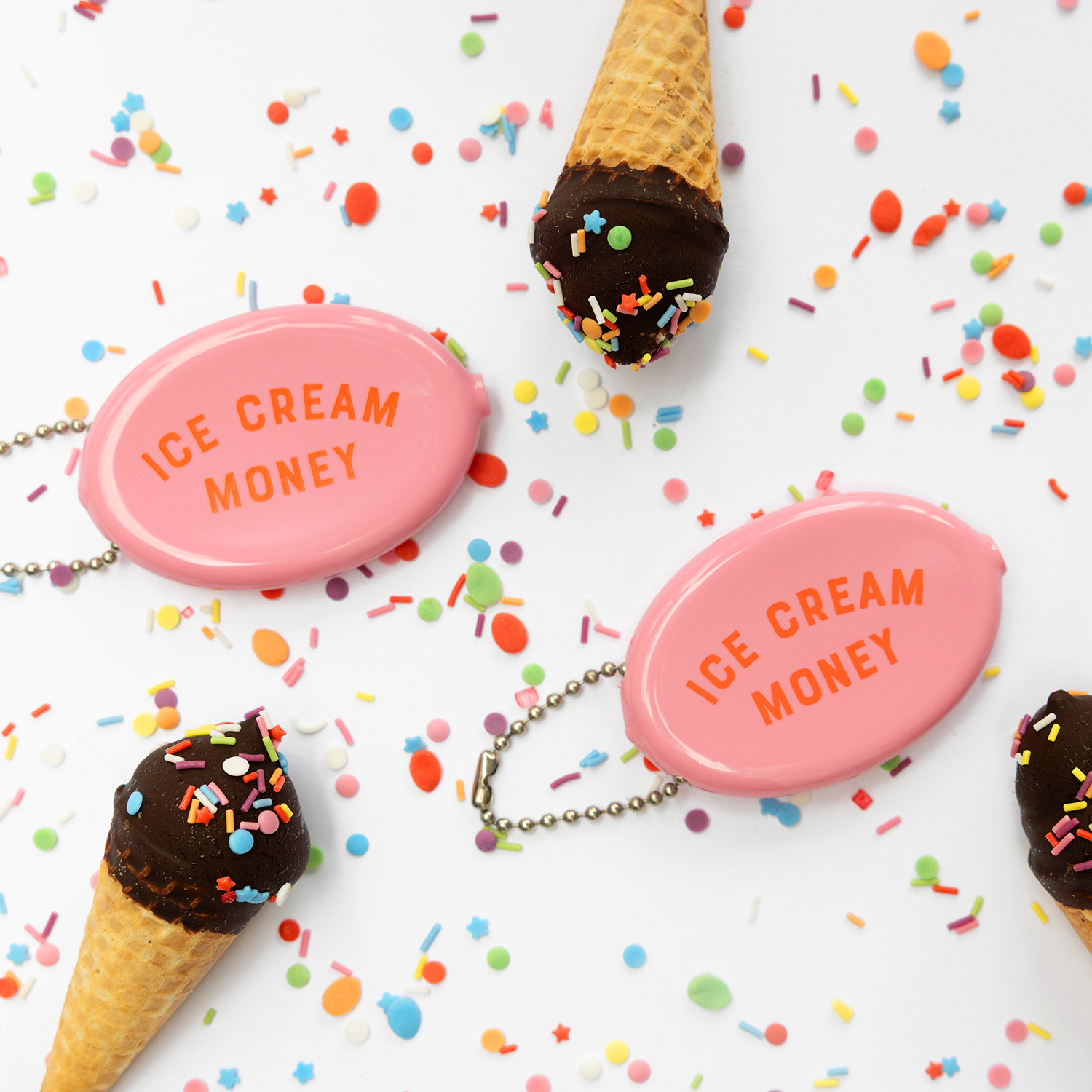Pink 'Ice Cream Money' pouches with chocolate ice cream cones on a white background with colorful sprinkles.
