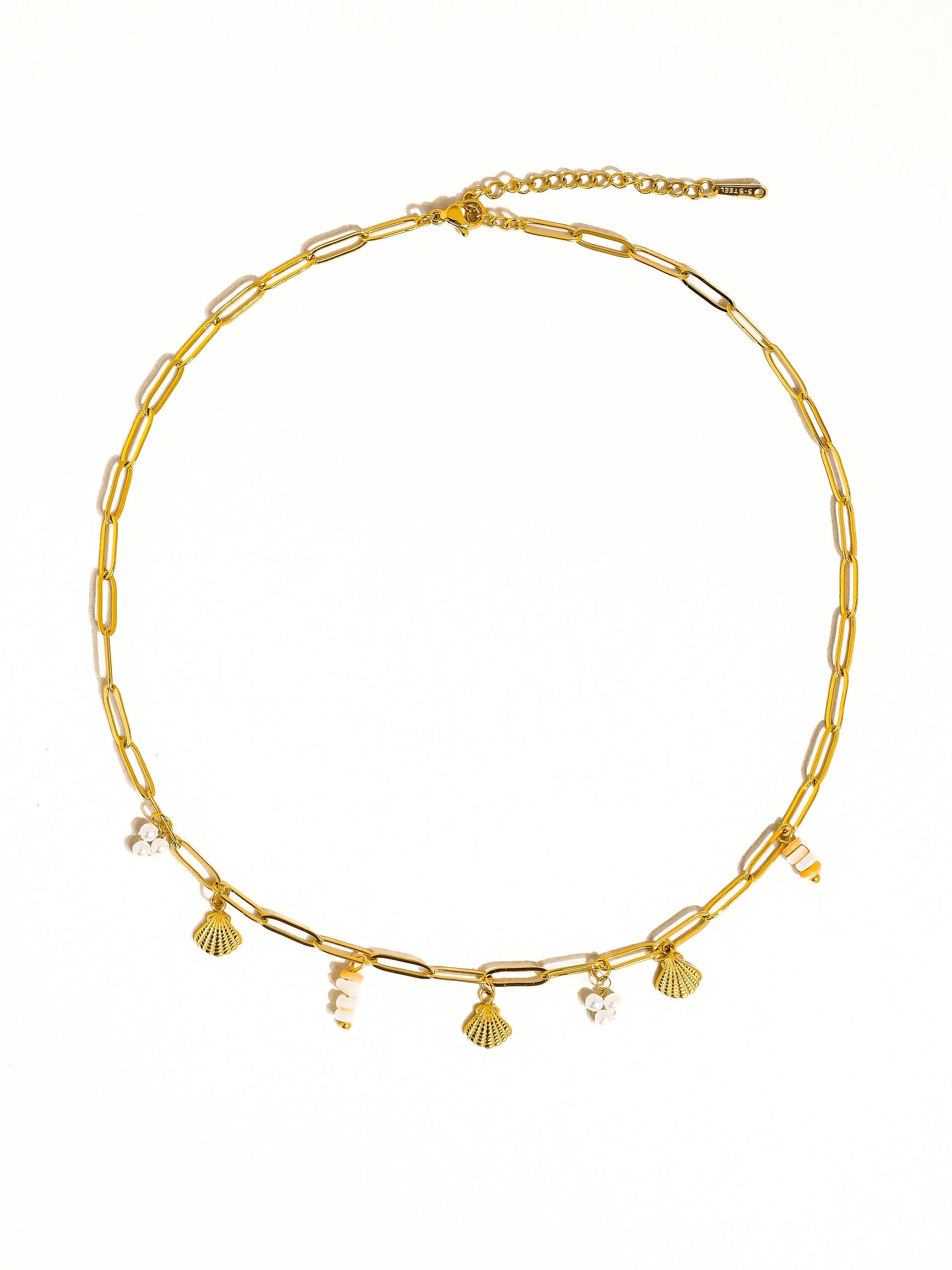 Gold necklace with shell and pearl charms on a white background