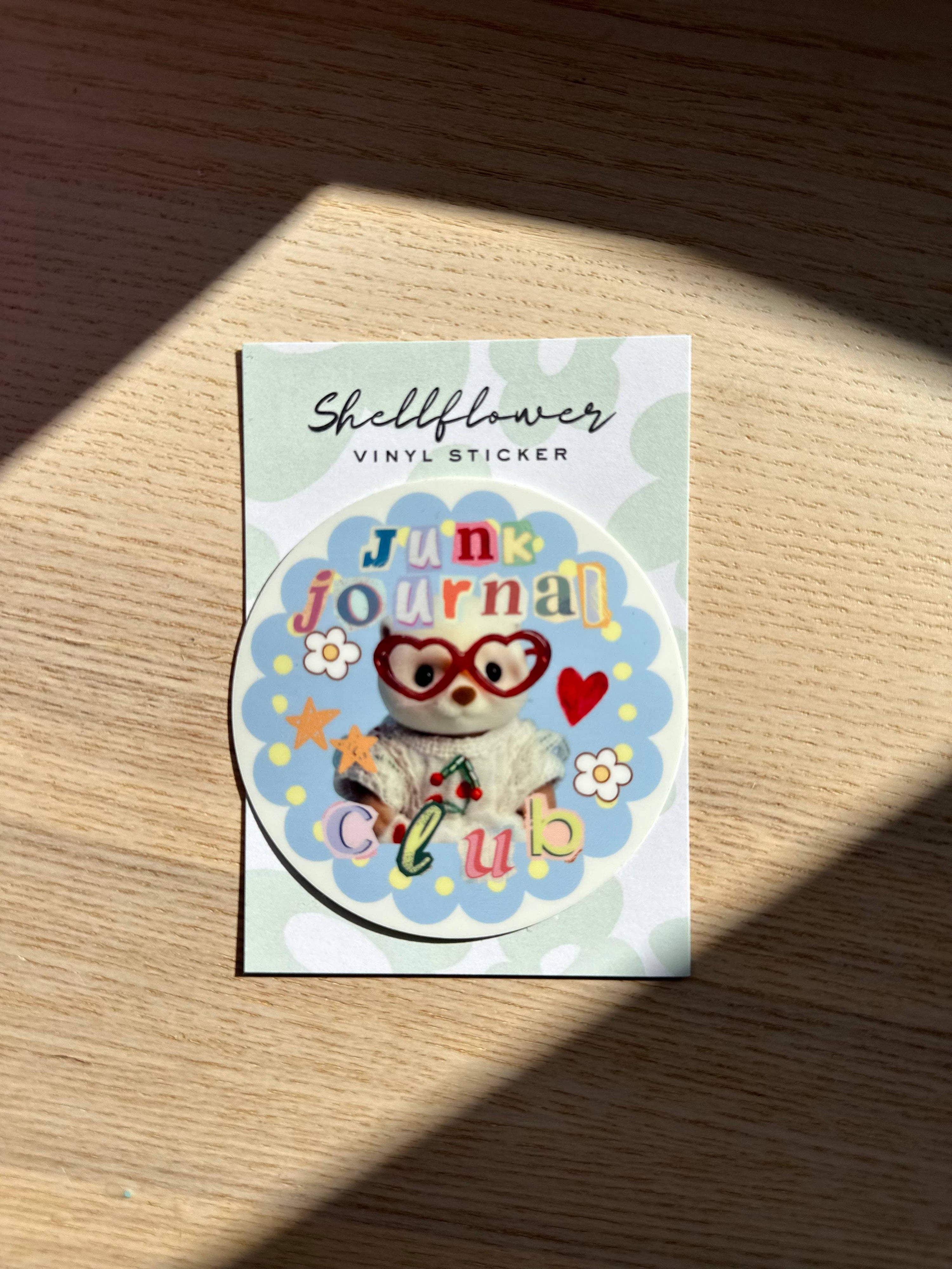 Sticker with 'Junk Journal Club' design on a wooden surface