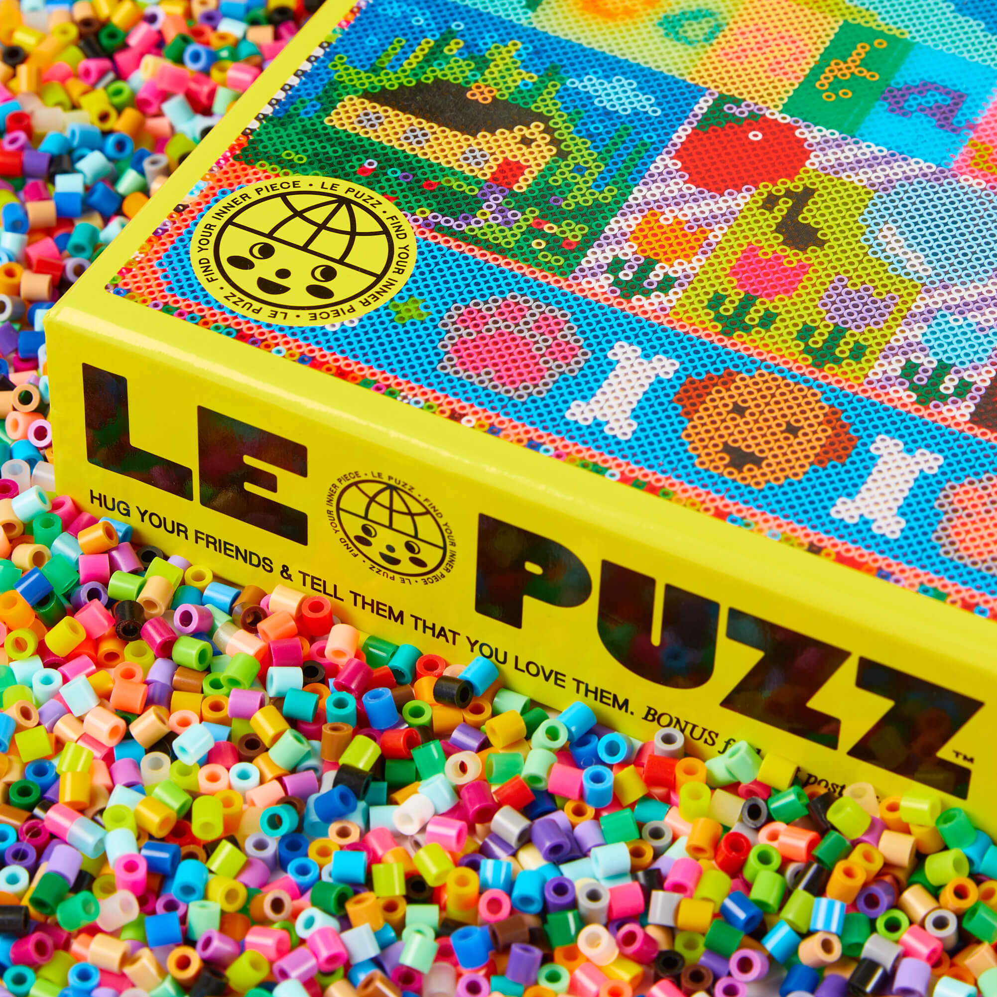 LE PUZZLE box with colorful beads scattered around
