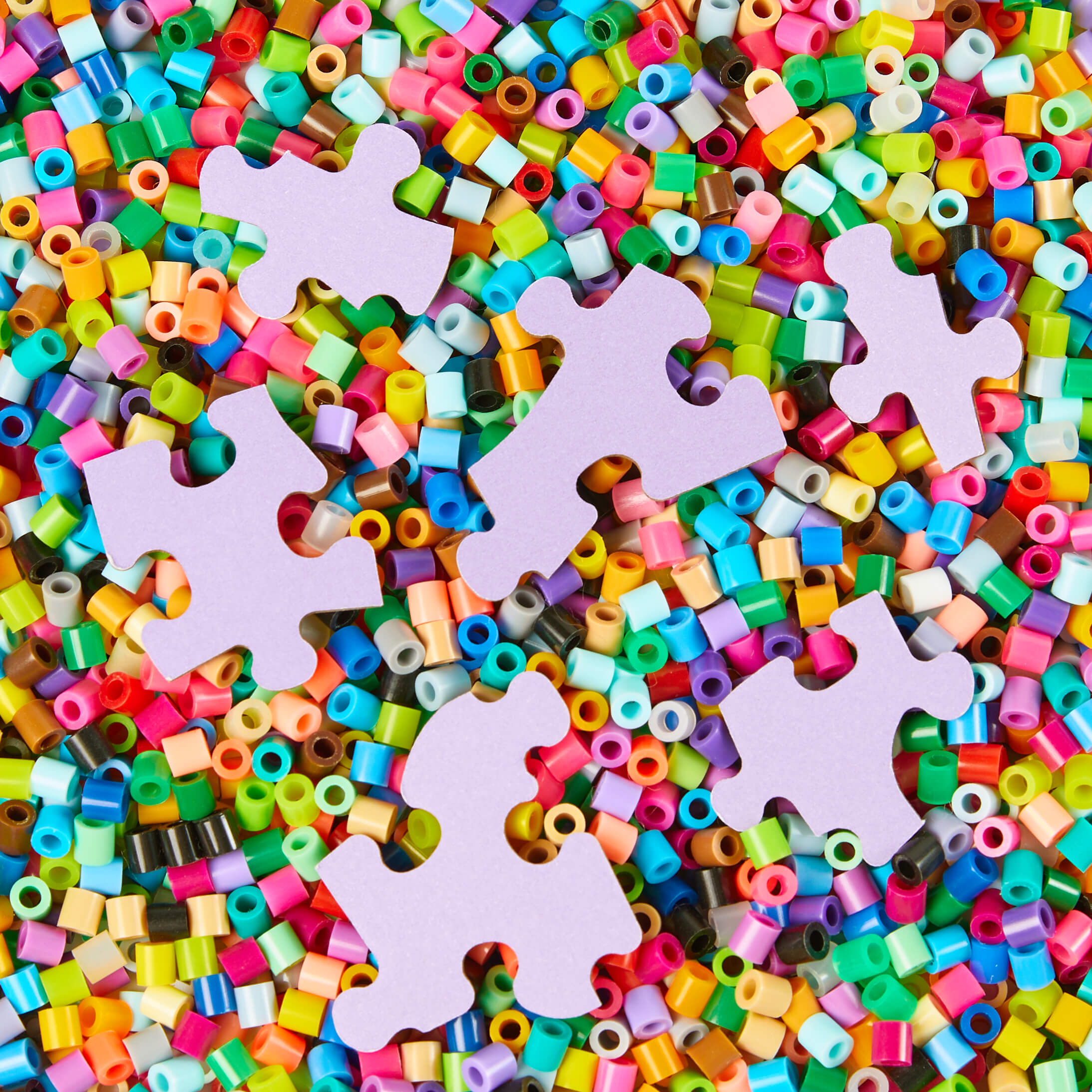 Colorful plastic beads with puzzle pieces on a multicolored background