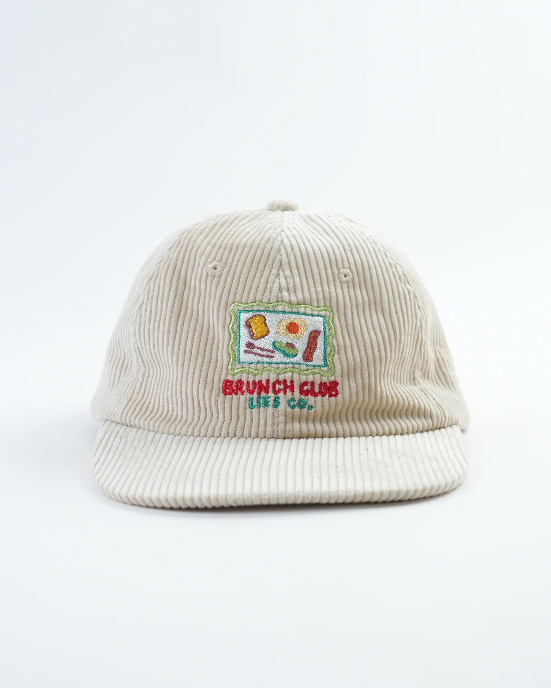 Beige corduroy cap with embroidered design on a white background