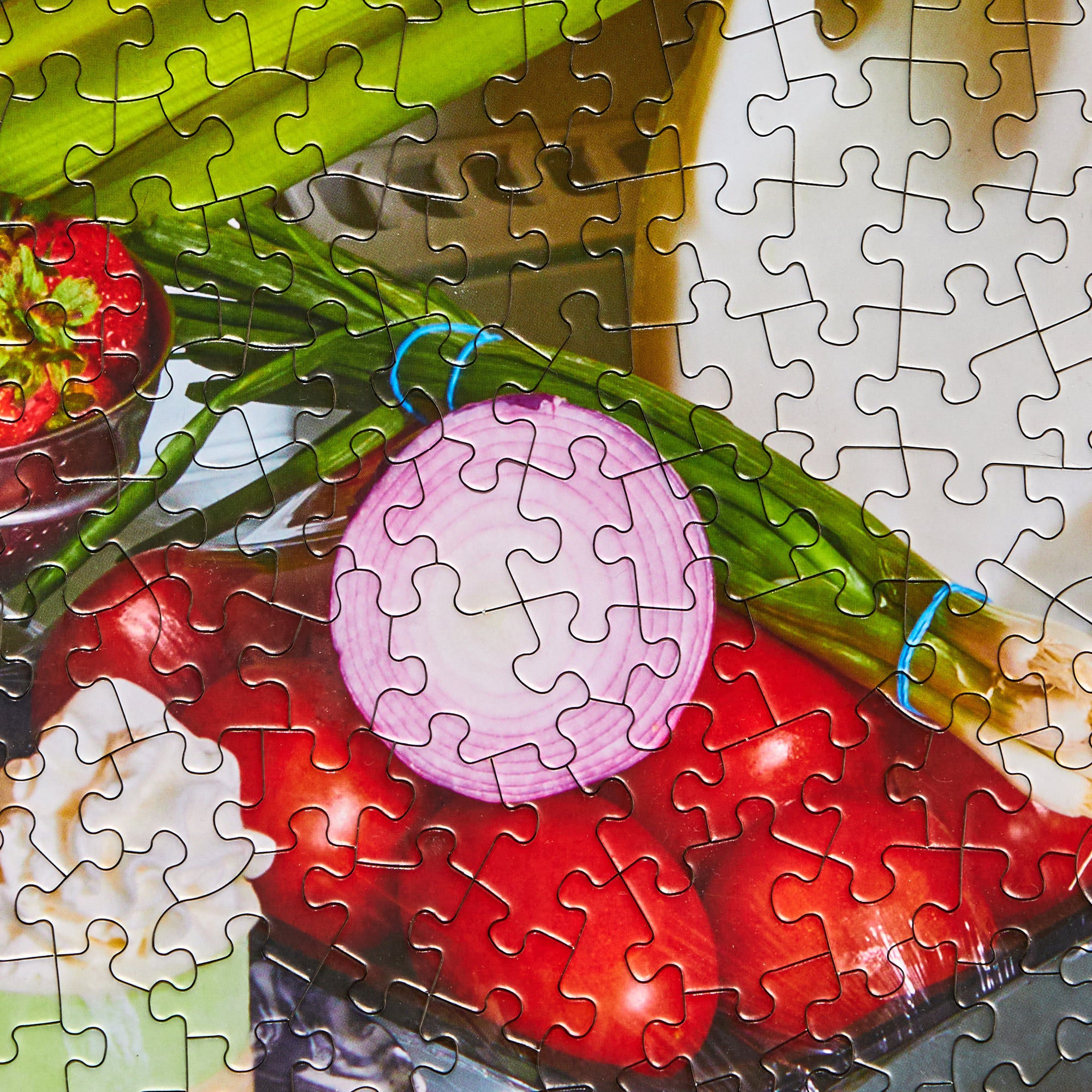 Close-up of Le Puzz Midnight Snack puzzle pieces showing vegetables including tomatoes, onions, and asparagus