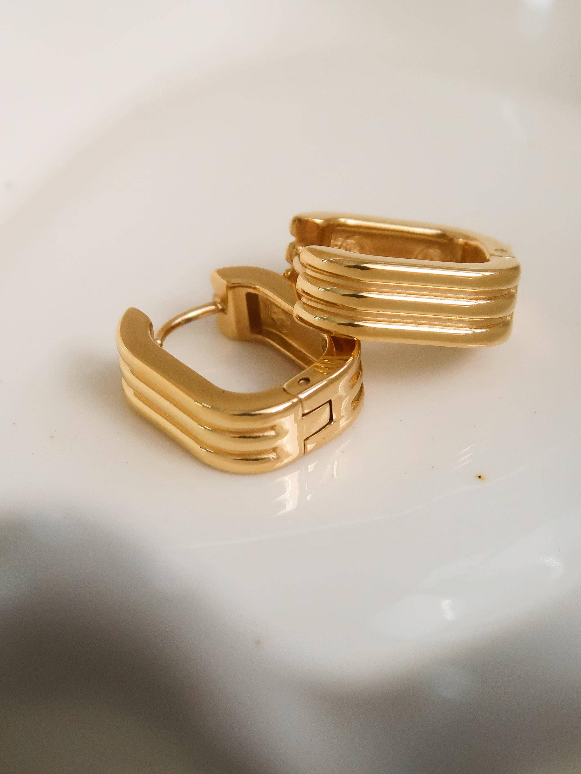 Gold hoop earrings on a light background