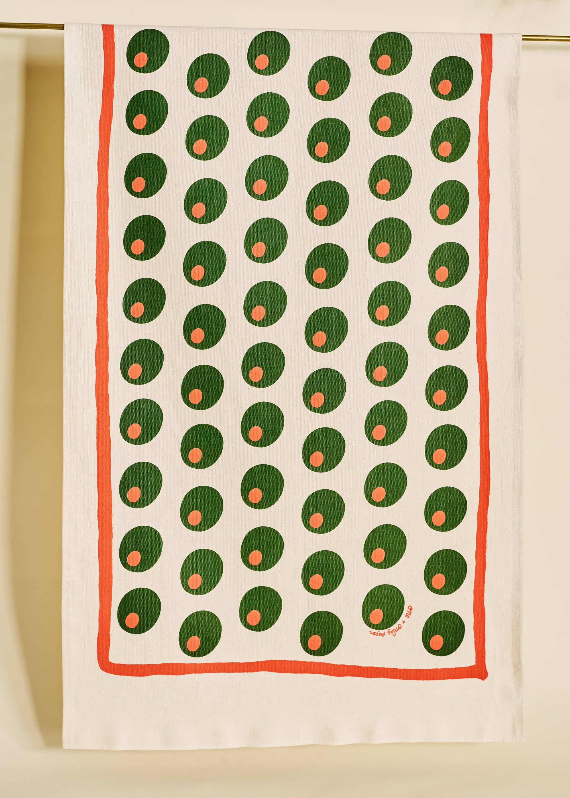 Tea towel with green and orange pattern on a white background