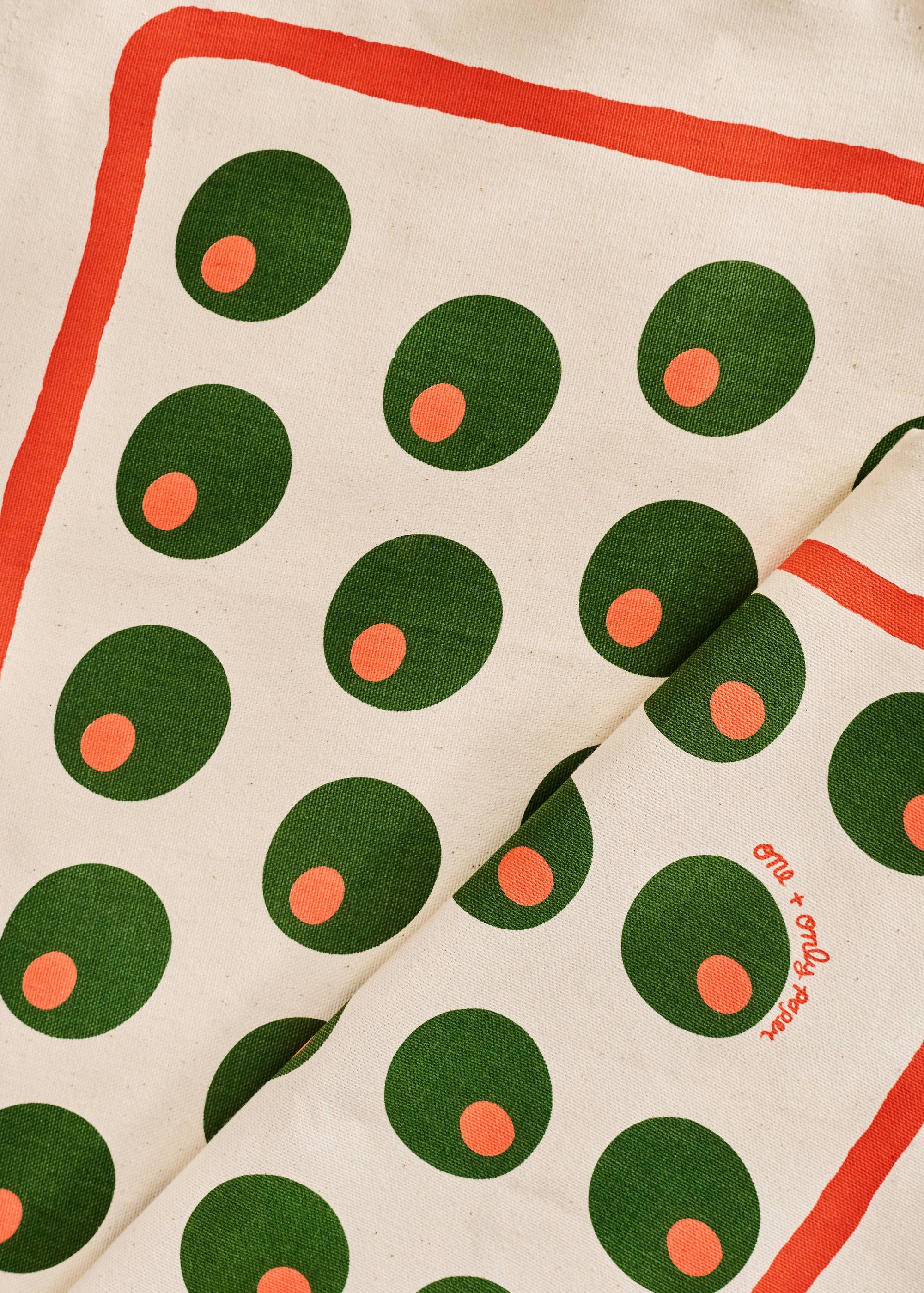 Fabric with green and red pattern on a beige background