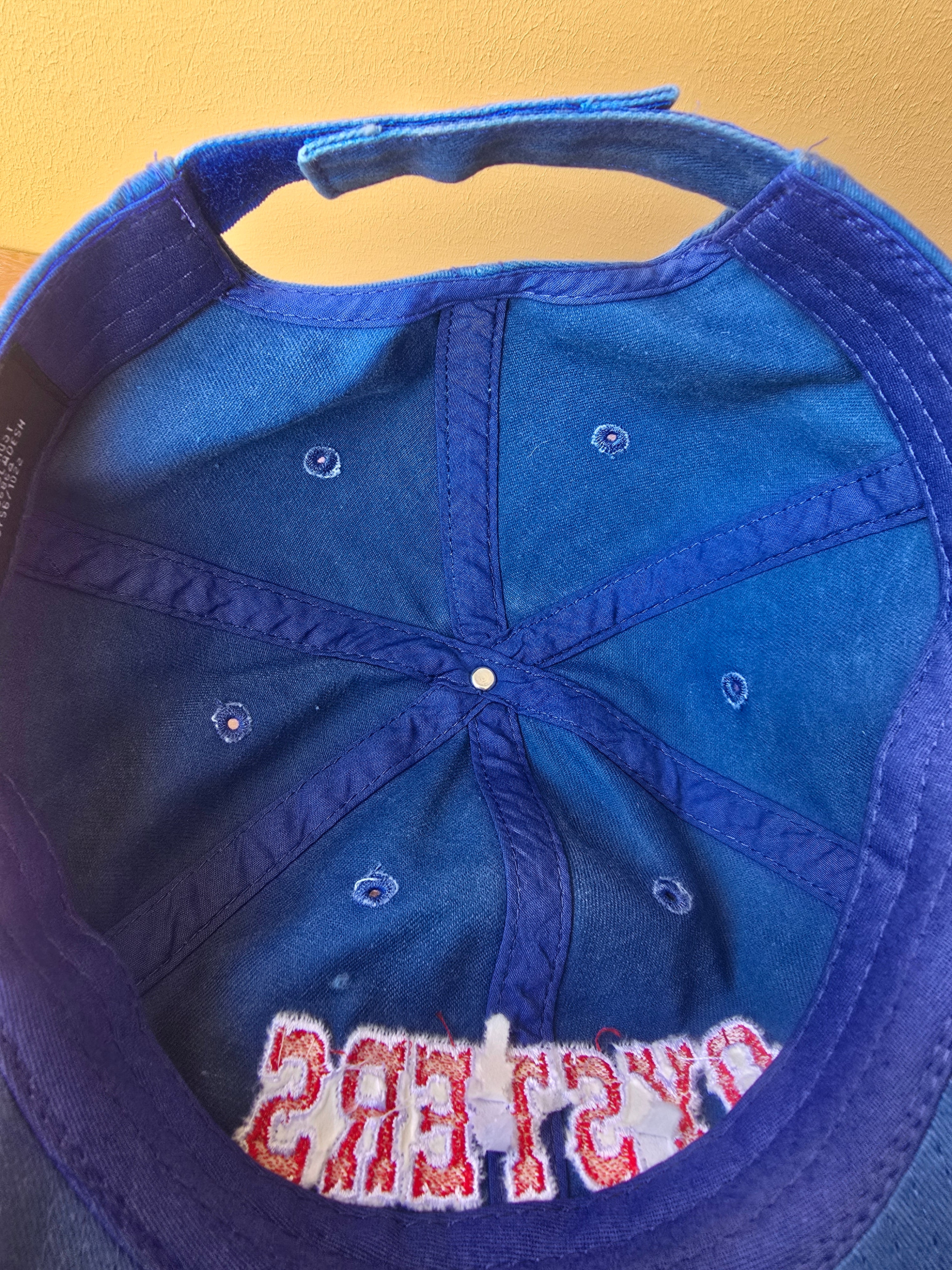 Blue baseball cap with text on a yellow background
