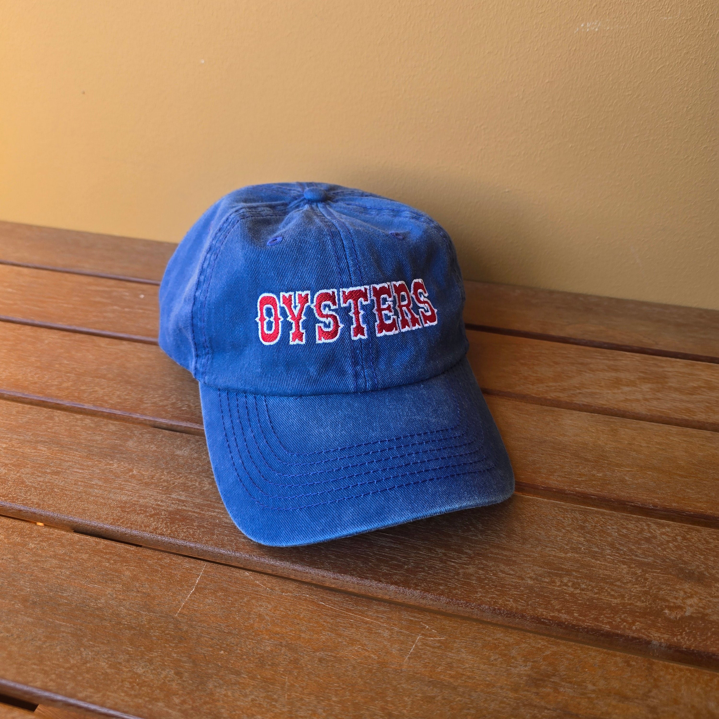 Blue cap with red and white text on a wooden surface