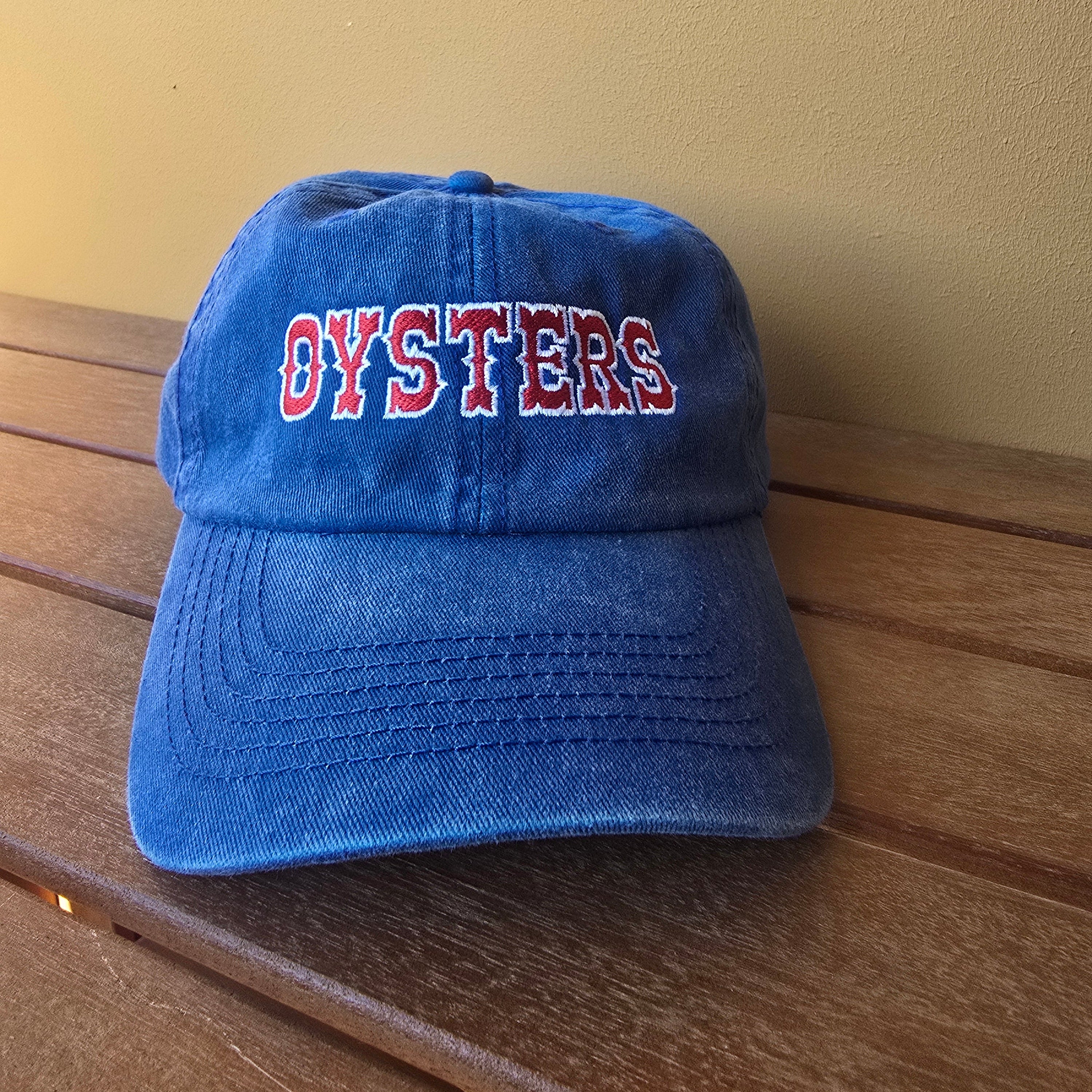 Blue cap with red text on a wooden surface