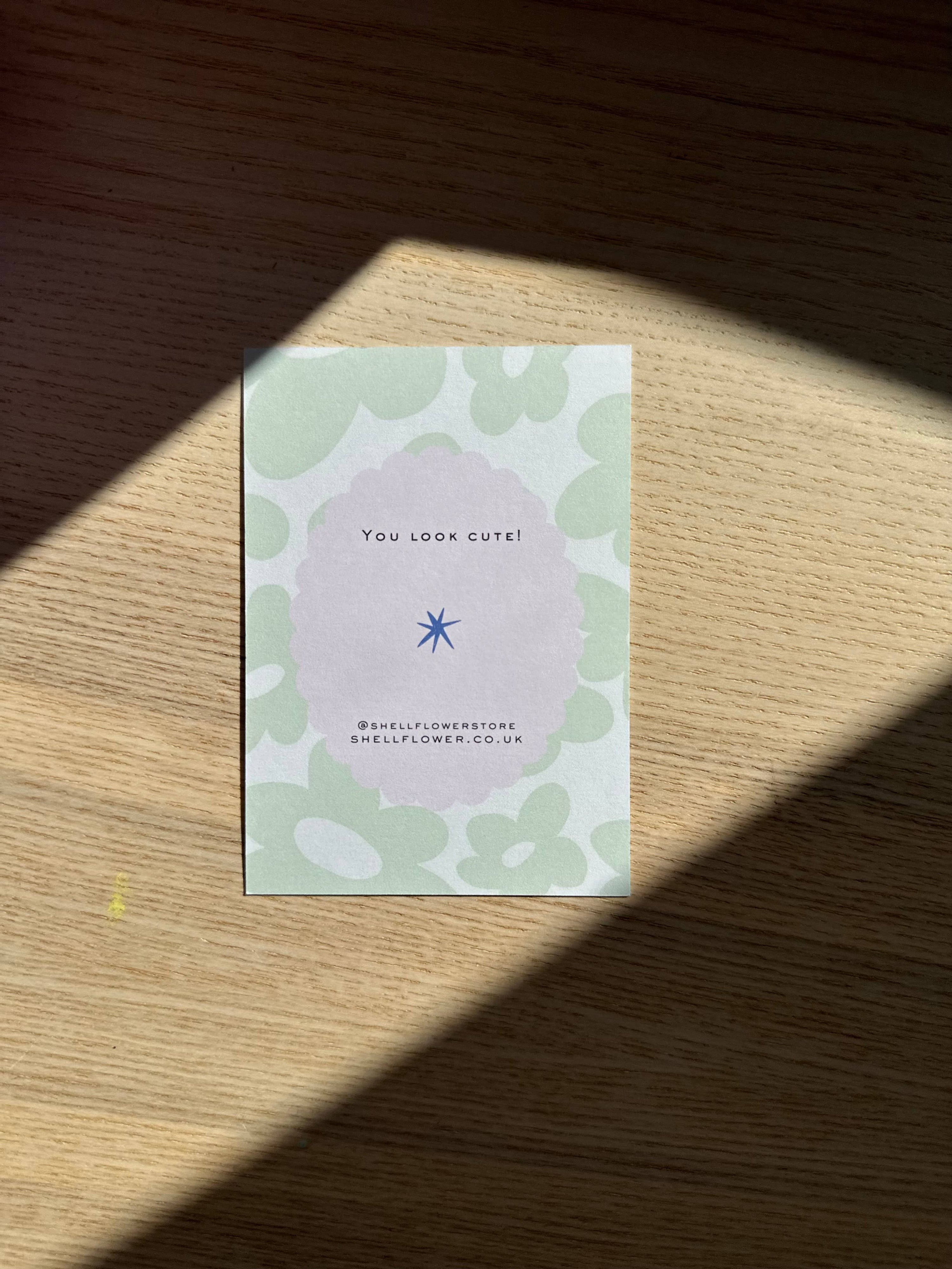 Greeting card with floral design and text on a wooden surface
