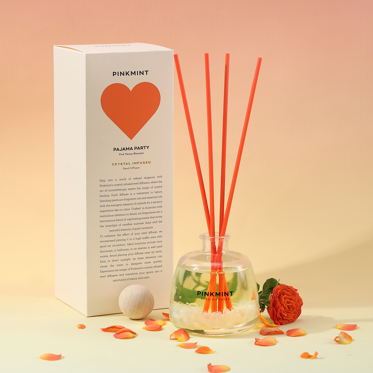 Pinkmint diffuser with reeds and packaging on a soft peach background