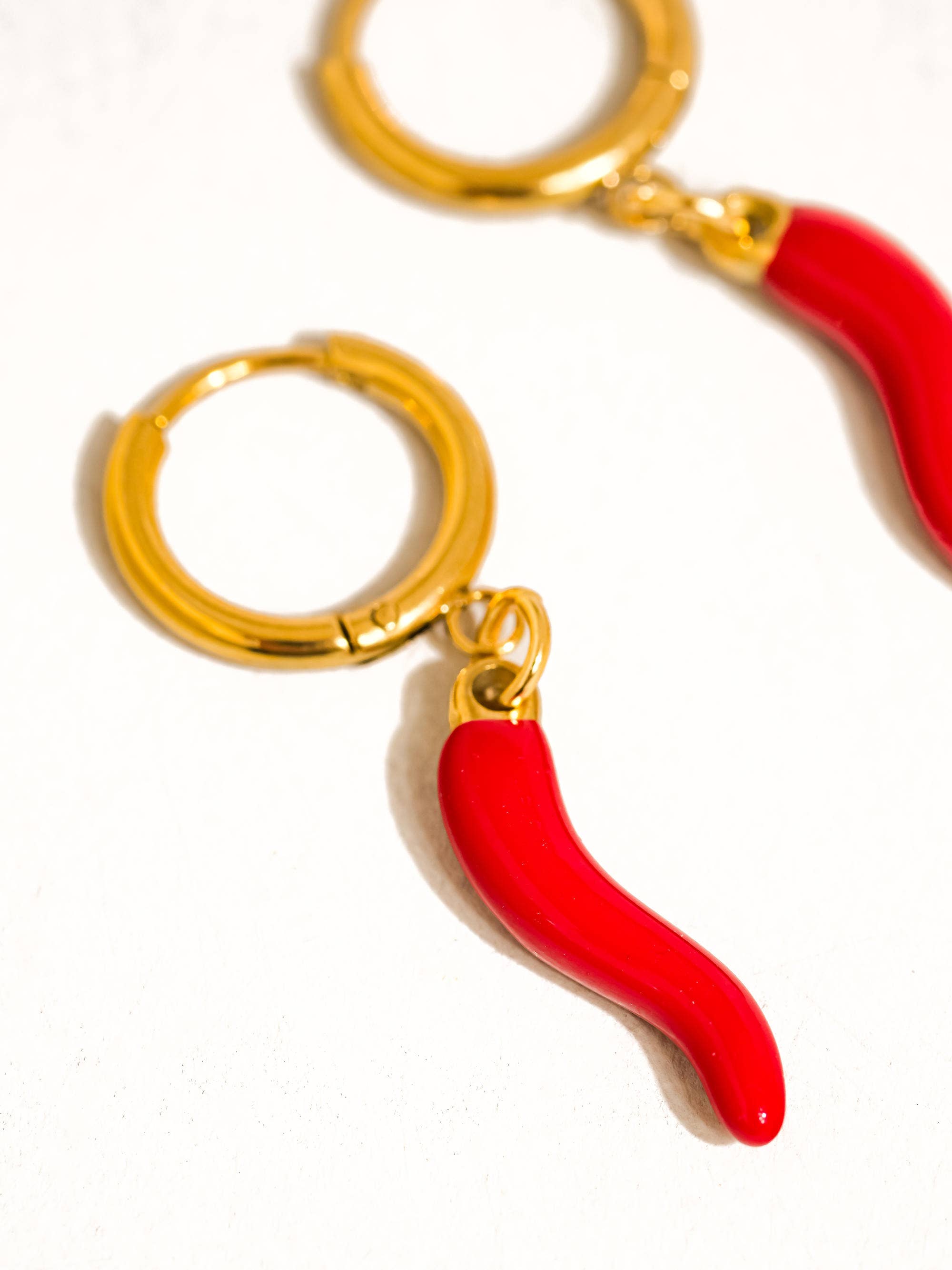 Red chili pepper keychain with gold ring on a white background