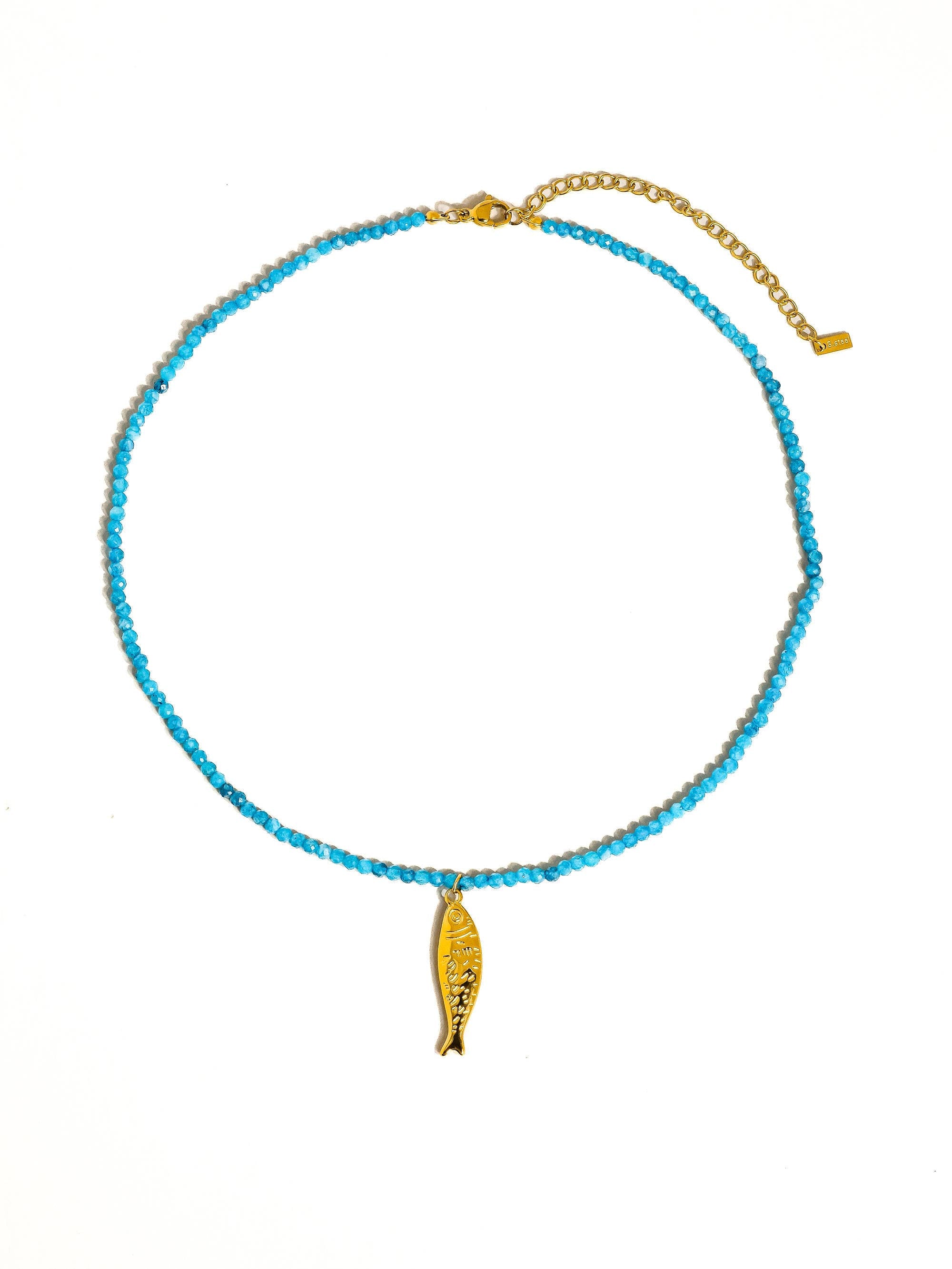 Necklace with blue beads and gold fish charm on a white background