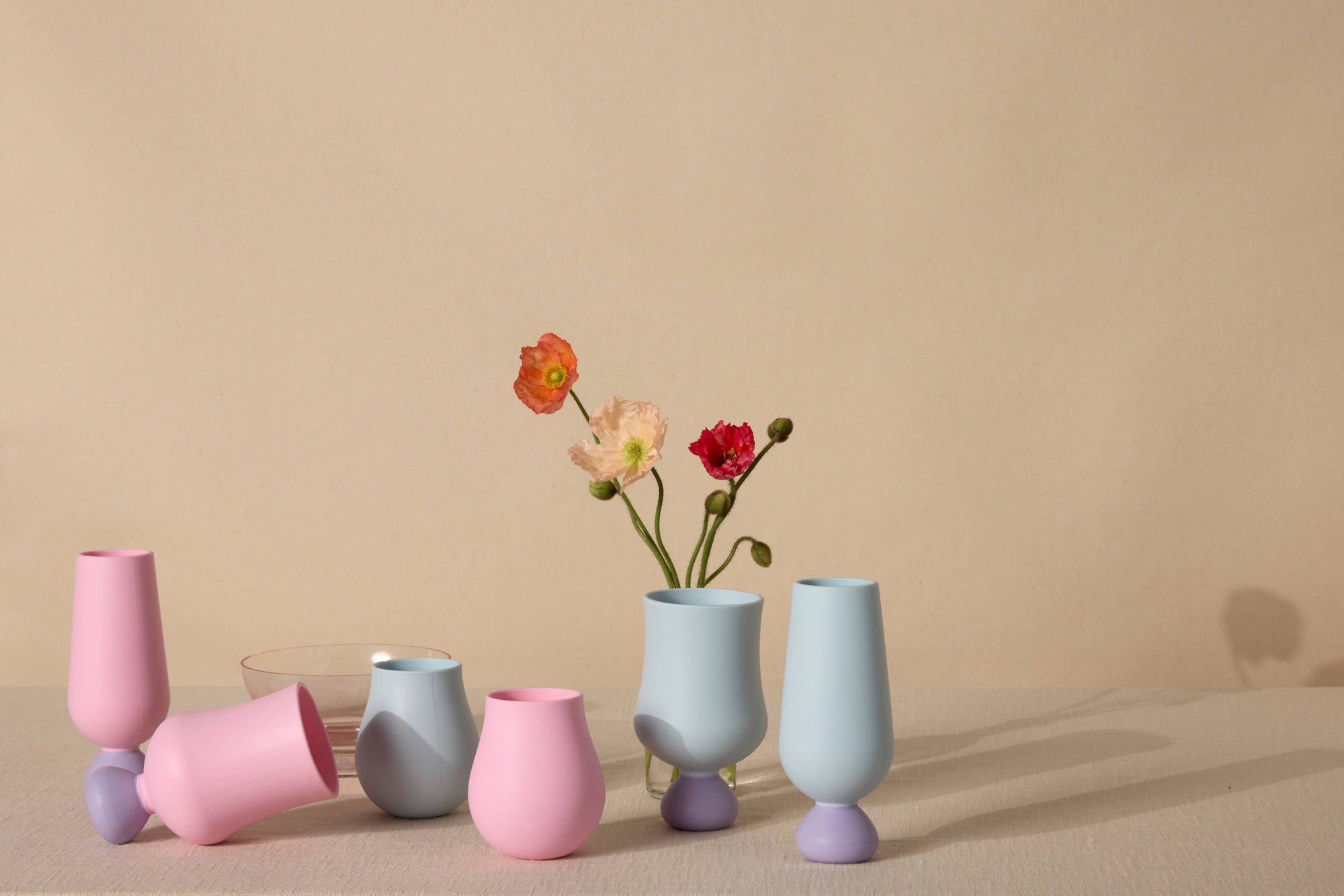 Set of colorful silicone cups  with flowers on a beige background