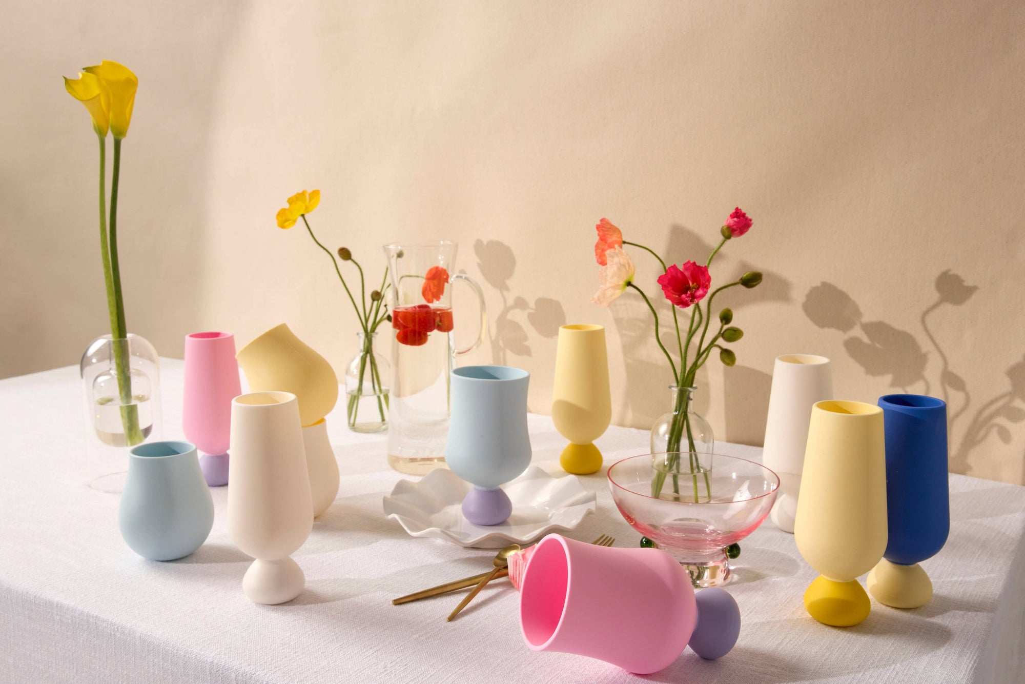 Colorful silicone cups and flower arrangements on a table with a neutral background