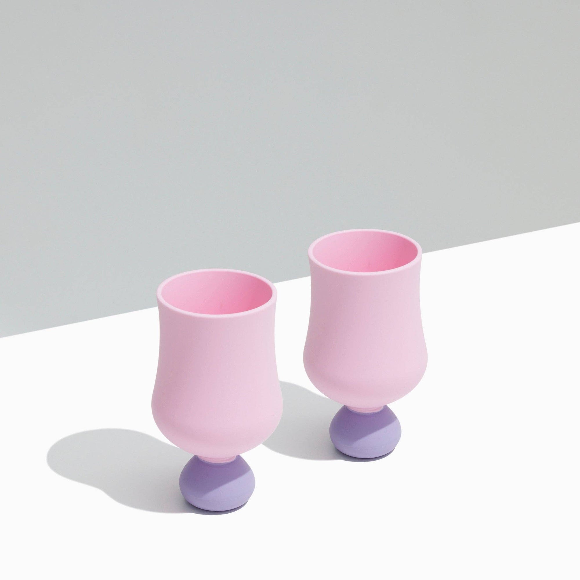 Two pink and purple silicone glasses on a light gray background