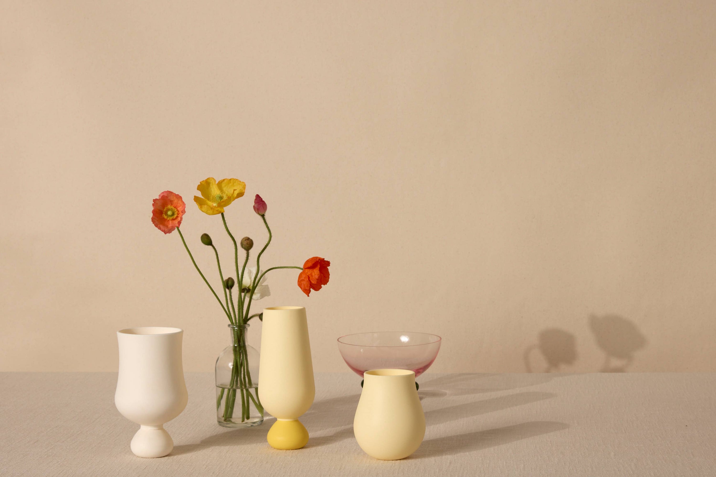 Set of colorful yellow and white silicone cups on a neutral background