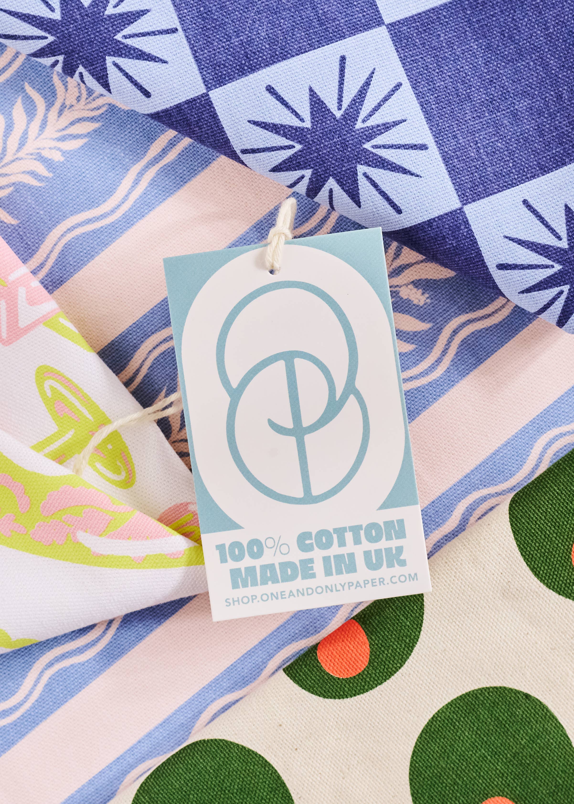 Product tag on a colorful fabric background with a brand logo and text.
