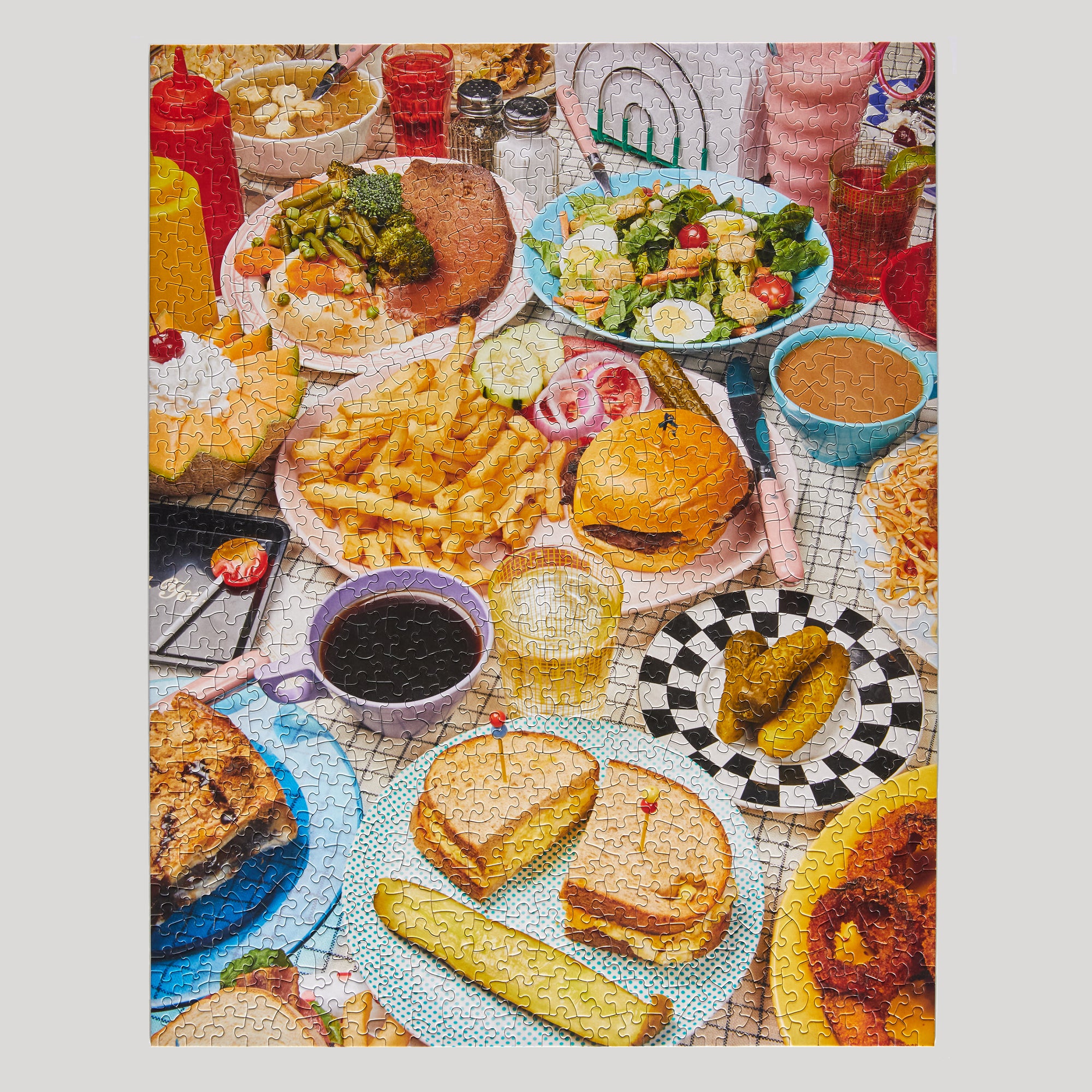 Colorful table setting with various food items including burgers, fries, and drinks.