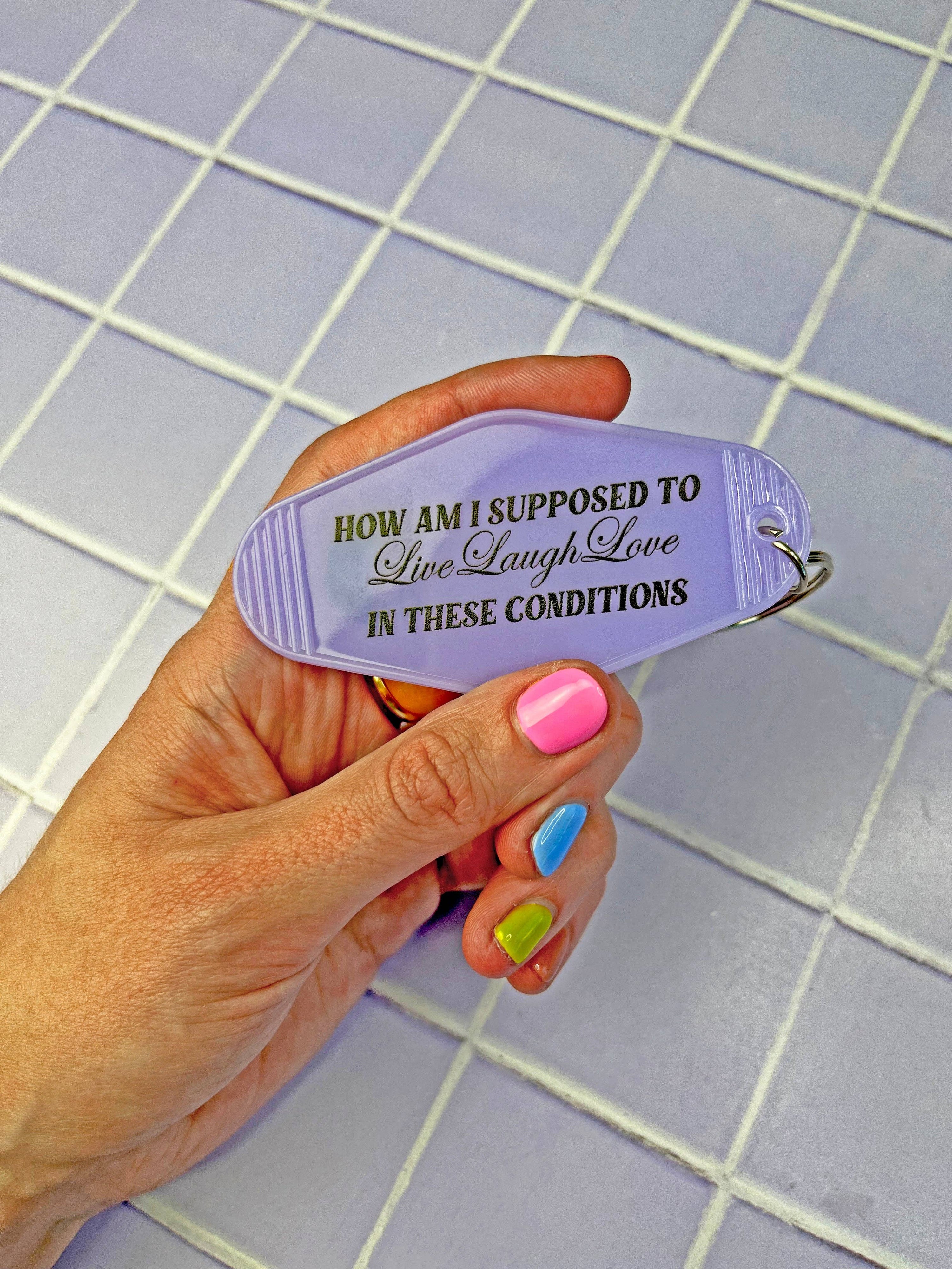 Hand holding a purple lighter with text against a tiled wall background