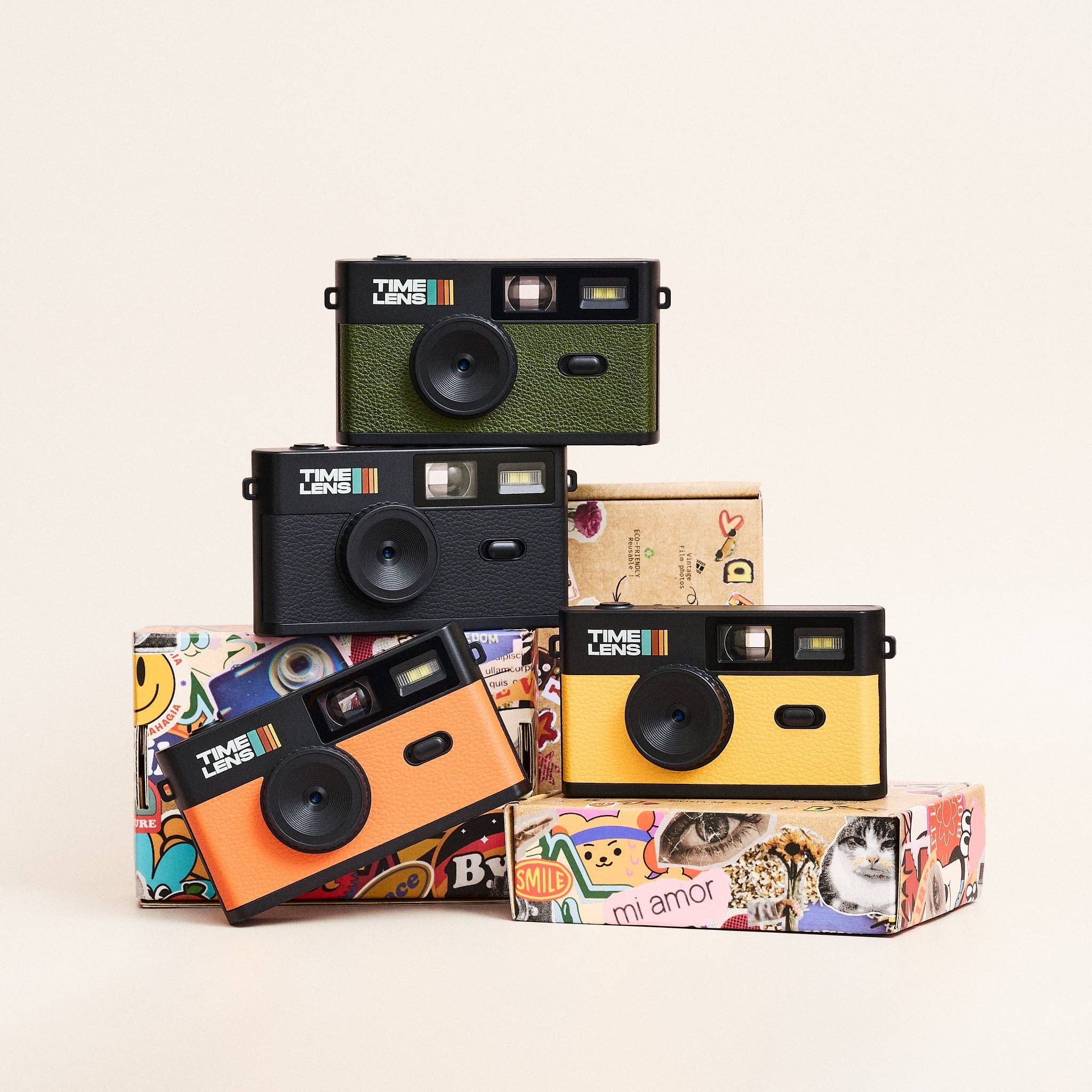 Stack of colorful digital cameras with various designs on a light background