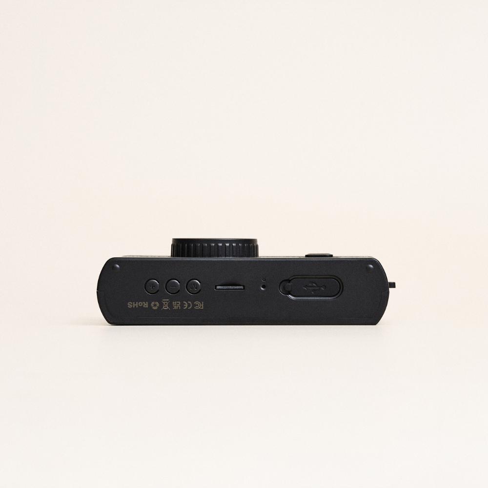 Black camera lens on a beige background