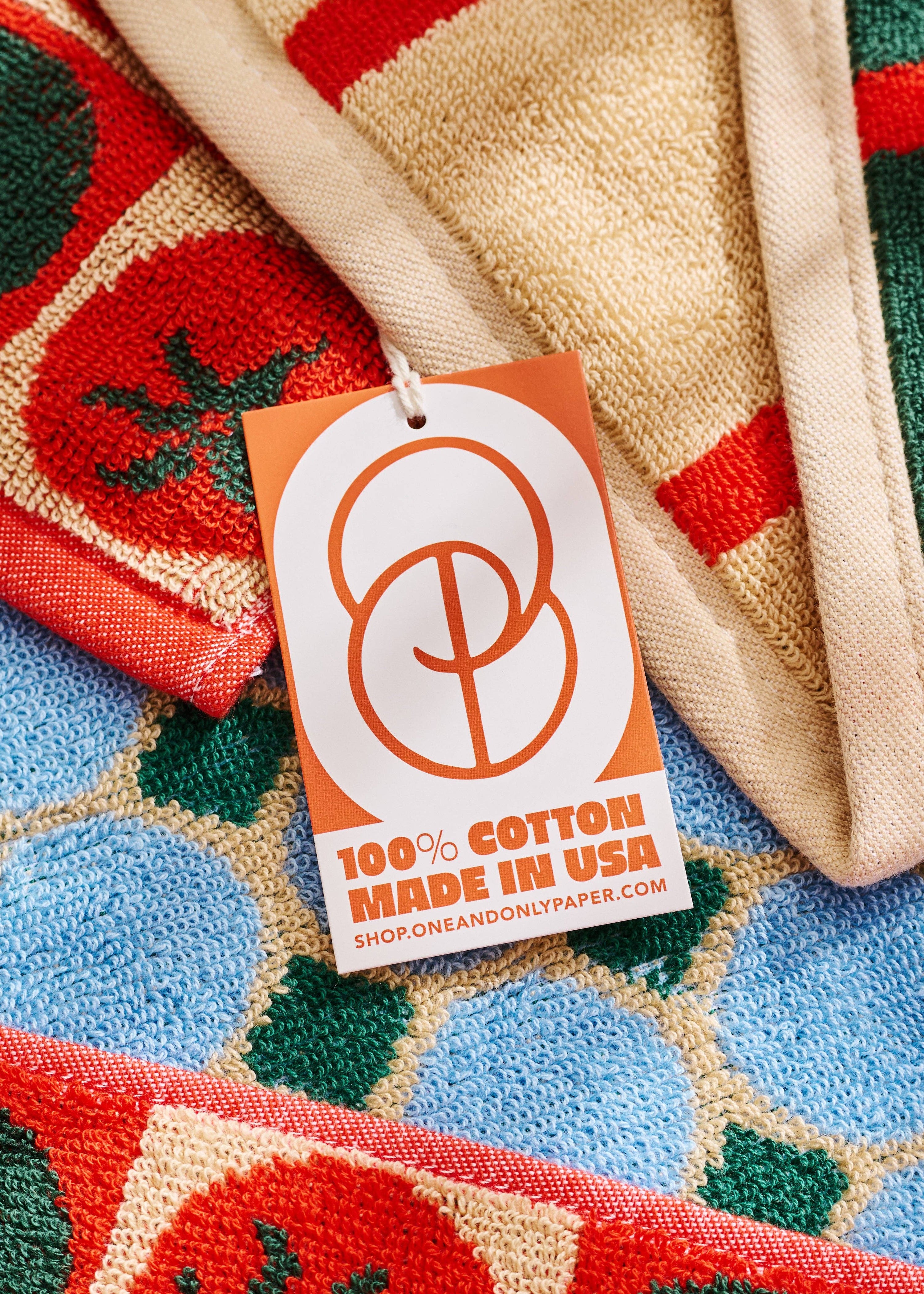 Colorful fabric with a '100% Cotton Made in USA' tag on a textured surface.
