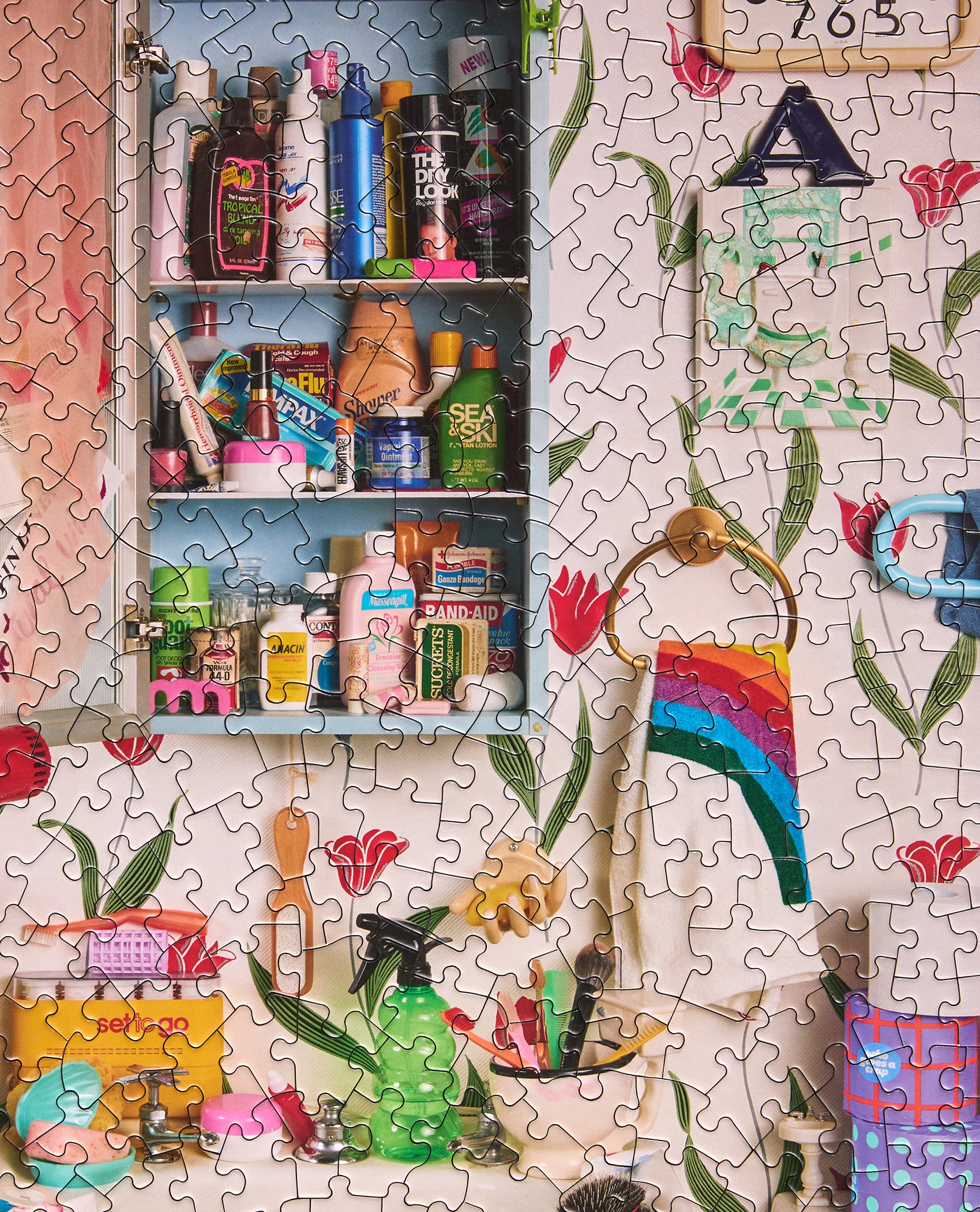 Completed Le Puzz Too-Da-Loo 500 piece puzzle showing a retro bathroom cabinet packed with colourful products