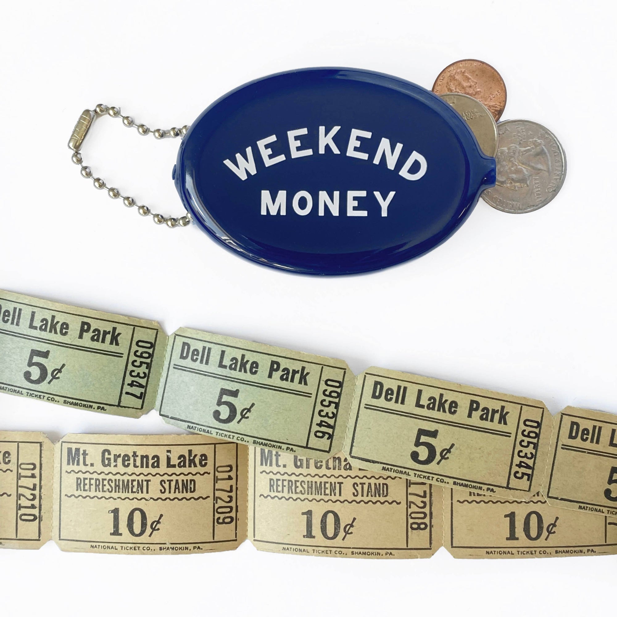 Blue coin purse labeled 'Weekend Money' with vintage-style tickets and coins on a white background